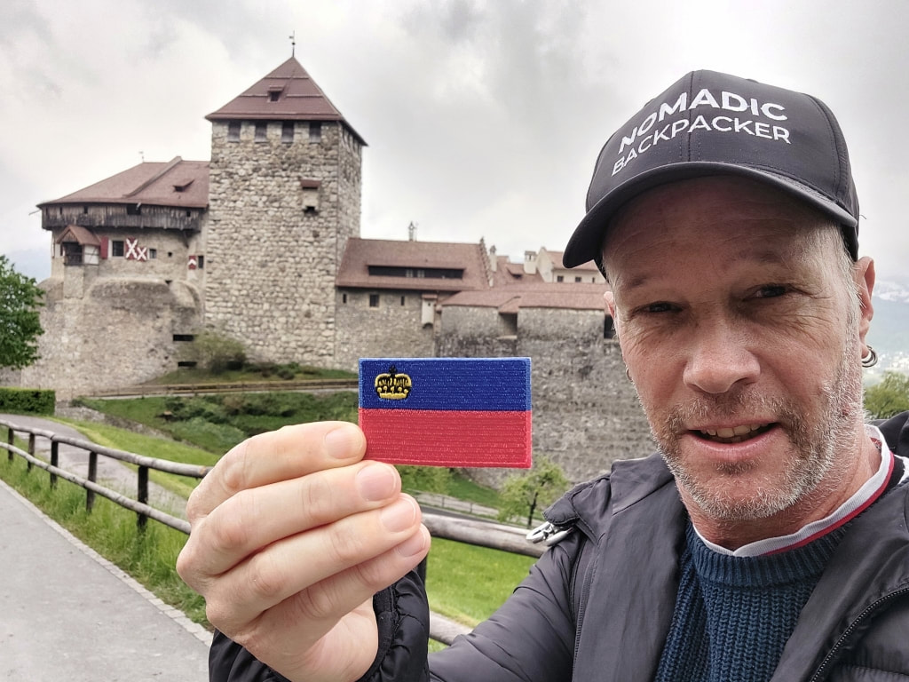 holding a flag in front of the Schloss in Vaduz