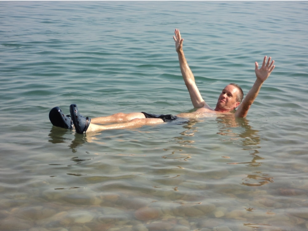 NomadicBackpacker floating in the Dead Sea Israel